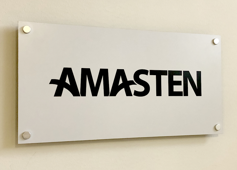 Fasadskylt med texten AMASTEN, i mattborstad aluminium
